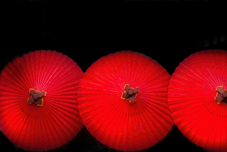 Three red umbrellas against a black background